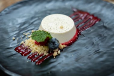 Panna Cotta böğürtlen ve sosla servis edilir.