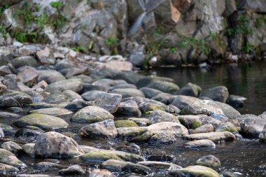Şelale deredeki taşların üzerinden akıyor.