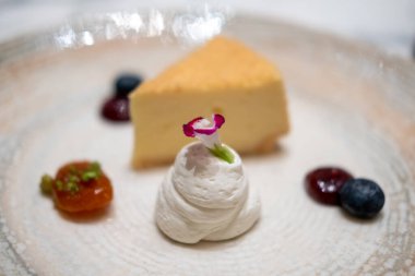 Böğürtlen soslu ve kremalı bir dilim cheesecake.