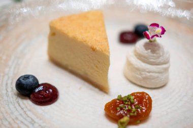 Böğürtlen soslu ve kremalı bir dilim cheesecake.