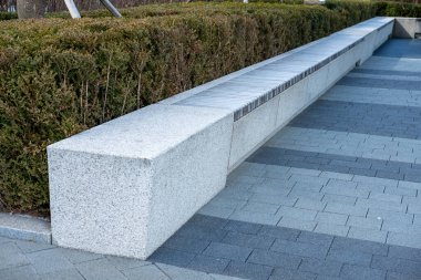 Halk parkında arka planda çalılarla otururken, kış boyunca.
