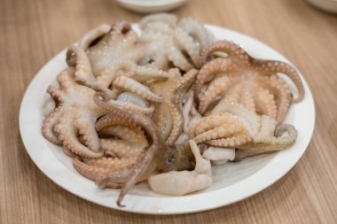 Çiğ kalamar tabakta barbekü için servis edilir.