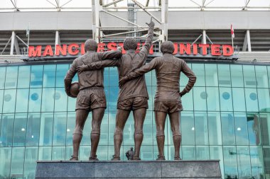 Manchester, İngiltere - 5 Ekim 2017: Eski Trafford Stadyumu George Best, Denis Law ve Sir Bobby Charlton 'ın üçlü heykeli ile Manchester United' ın evi