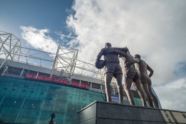 Manchester, İngiltere - 5 Ekim 2017: Eski Trafford Stadyumu George Best, Denis Law ve Sir Bobby Charlton 'ın üçlü heykeli ile Manchester United' ın evi