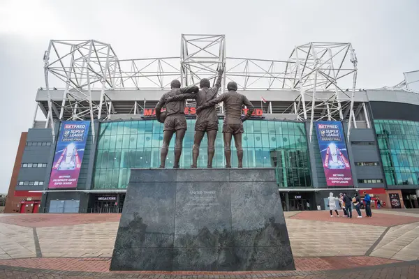 Manchester, İngiltere - 5 Ekim 2017: Eski Trafford Stadyumu George Best, Denis Law ve Sir Bobby Charlton 'ın üçlü heykeli ile Manchester United' ın evi