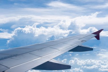 Gökyüzü, bulut ve hava manzarası uçağın penceresinden görülüyor.