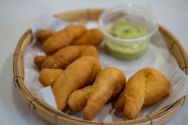 Pa Thong Ko, Tayland usulü Çin usulü hamur tatlısı Pandan Muhallebi ile servis edilir.