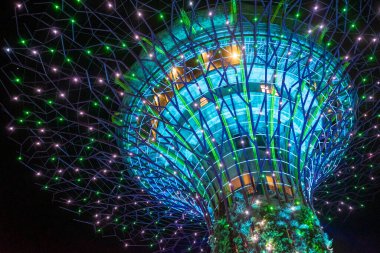 Gece yarısı ışık gösterisi sırasında Singapur 'da, Garden By the Bay' deki Supertree Grove 'da. Yüksek ağaç benzeri yapılara sahiptir..