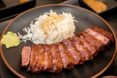 Lahanayla servis edilen Gyukatsu ya da sığır pirzolası. Kızarmış sığır pirzolası içeren geleneksel bir Japon yemeği..