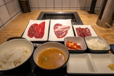 Tabakta Kore usulü ızgara var. Pirinç ve çorbalı paslanmaz ızgara önünde. Yumuşak odaklı az pişmiş et.