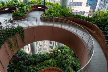 Singapur - 8 Mart 2024: Yeşil Oasis manzarası, CapitaSpring binasının ortasındaki bir açık hava bahçesi şehrin ortasında doğayla yeniden bağlantı kurmayı sunuyor
