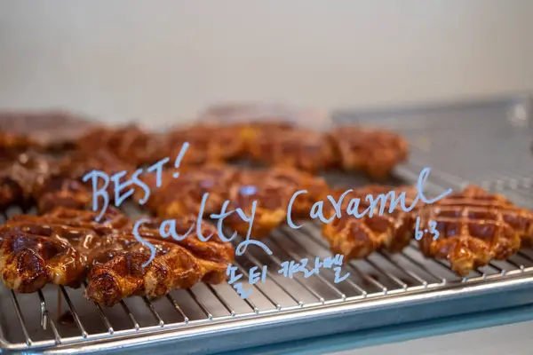 stock image Croffle, a hybrid of a croissant and waffle which is a popular pastry in South Korea, in the display with Korean text 'salty caramel'