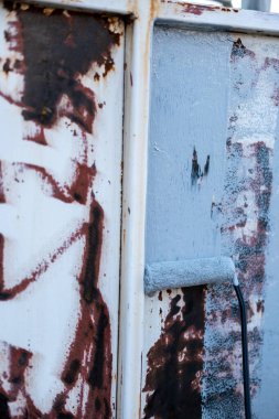 Paslı metal panelde paslanma önleyici boya silindiri var.
