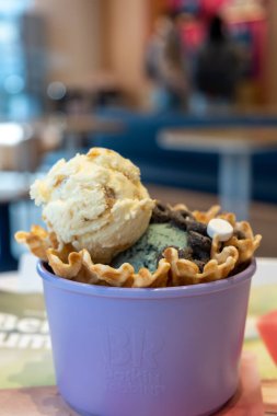 Seoul, South Korea - 17 March 2024: A cup of Baskin-Robbins mint chocolate and cheesecake ice cream with waffle. It is an American multinational chain of ice cream and cake specialty shop clipart