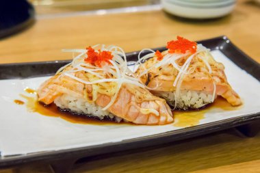 Yanmış somon peynirli suşi.