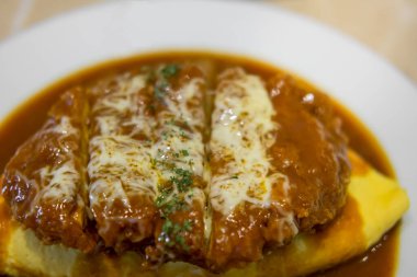 Omu pilavı, pirinçli omlet kızarmış domuz eti ya da tonkatsu, köri sosu. Japon yemeği.