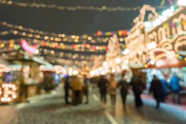 Moskova, Rusya 'daki Noel pazarında yürüyen, alışveriş yapan insanların bulanık görüntüsü.
