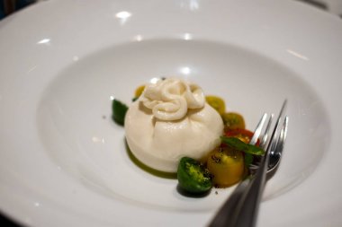 Burrata, mozzarella ve kremadan yapılmış İtalyan inek sütü peyniri, tabakta servis edilir.