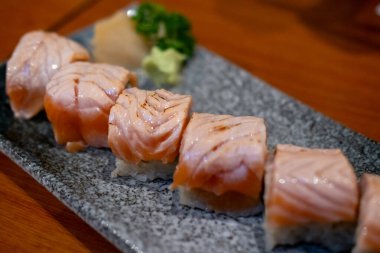 Yanmış Somon Suşi rulosu tabakta servis ediliyor.