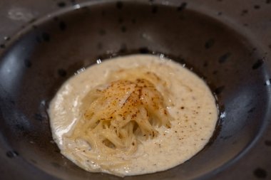 Tabakta servis edilen yanmış mantarlı spagetti.