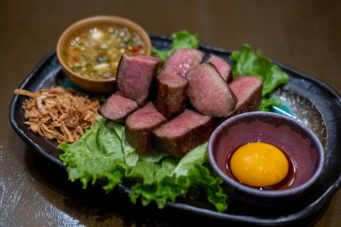 Yumurta sarısı ve sosla servis edilen ızgara sığır dili.