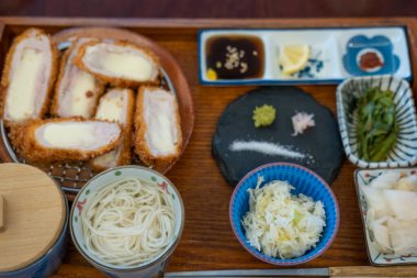 Peynirli Tonkatsu, soslu kızarmış domuz eti, pilav ve çorba restoranda servis edilir.