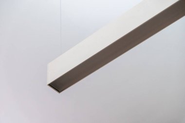 Prizmatik bir kapak içeren askıya alınmış doğrusal profil ışıklandırması, üniforma ve parıltısız aydınlatma sağlamak için tasarlanmış, modern ofis ortamları için ideal.