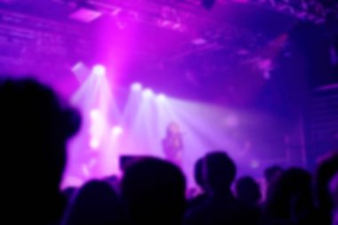 Arka plan bulanık, Bokeh, kapalı konser aydınlatma ile sahnede seyirci, ellerini havaya kaldır ve müzisyenler tezahürat siluet