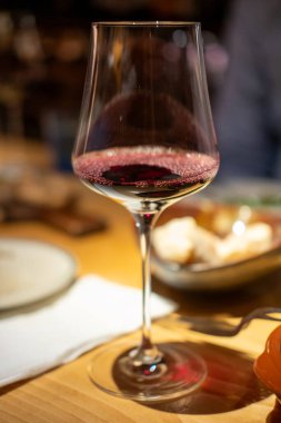 Restaurantta arka planı bulanık bir bardak kırmızı şarap.