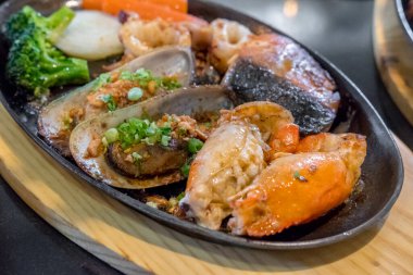 Karides, midye ve somon da dahil olmak üzere ızgara deniz ürünleri.