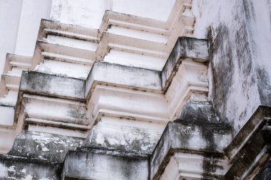 Dini bir binanın köşesi, pagoda, beyaz taş mimari katmanları ve yaşlanma ve yıpranma belirtileriyle dolu..