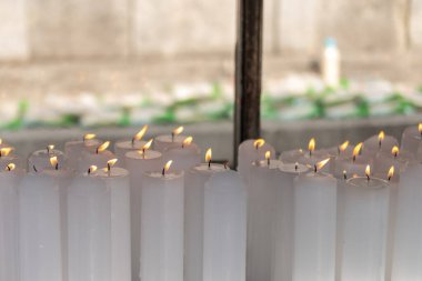 Tapınakta bir grup büyük beyaz mum.