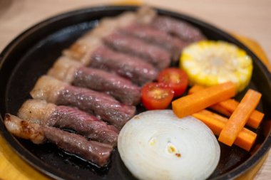 Çeşitli sebzelerle servis edilen ızgara biftek.