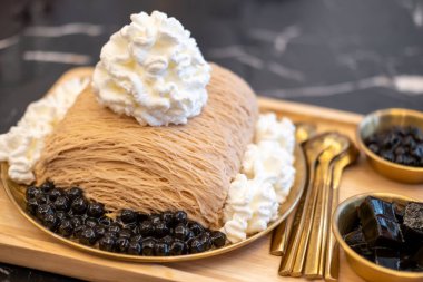 Çay bingsu, jöle, boba ve krema ile servis edilir.