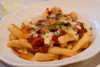 Tabakta peynir ve pastırma ile yakın plan patates kızartması.