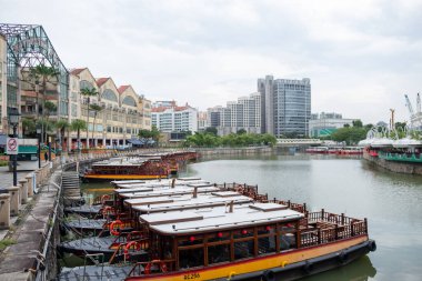 Singapur - 21 Ekim 2022: Riverside Point, rıhtım boyunca yanaşmış geleneksel tekneleri ile. Yemek, gece hayatı ve manzaralı nehir turları için popüler bir yerdir..