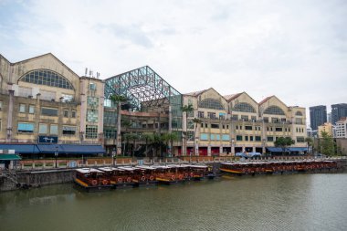 Singapur - 21 Ekim 2022: Riverside Point, rıhtım boyunca yanaşmış geleneksel tekneleri ile. Yemek, gece hayatı ve manzaralı nehir turları için popüler bir yerdir..