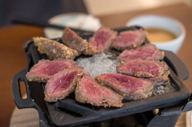 Izgarada Gyukatsu ya da sığır pirzolası. Kızarmış sığır pirzolası içeren geleneksel bir Japon yemeği..