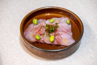 Japon Yuzu Ponzu soslu kurutulmuş balık tabakta servis edilir.