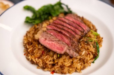 Tabakta az pişmiş biftek ile karıştırılmış fesleğen. Pad Kra Pao olarak bilinen popüler bir Tayland yemeği.