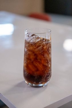 Masada bir bardak kola ve bokeh arkaplan.