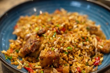 Kızarmış domuz eti, tuzlu ve acılı, tabakta servis edilir.