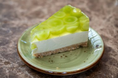 Muscat üzümlü jöle parlat, peynirli kekin üzerine, tabakta ufalanan tabakla birlikte.