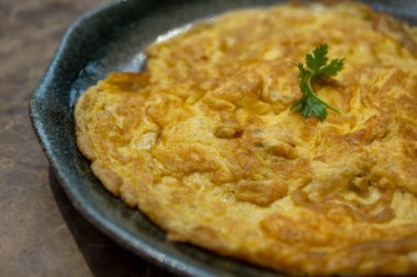 Omletin yakın plan fotoğrafı, üstünde kişniş var.