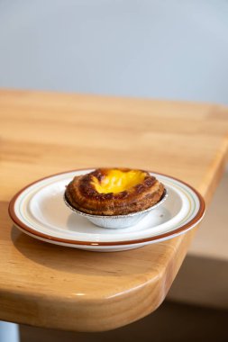 Yumurtalı tart, Kanton mutfağında bulunan bir çeşit kremalı tart, ahşap masada servis edilir.