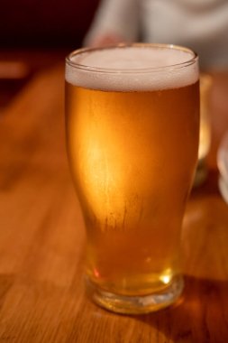 Arka planı bulanık bir bardakta birayı kapat.