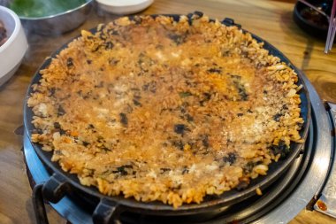 Tavada kızarmış pirinç, pirinç, yosun ve sos karışımı ile yapılır. Kore yemeği.