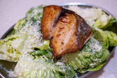 Tabakta soslu ızgara balık salatası.