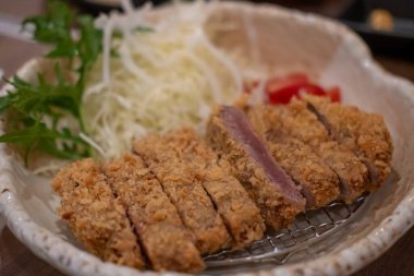 Lahanayla servis edilen Gyukatsu ya da sığır pirzolası. Kızarmış sığır pirzolası içeren geleneksel bir Japon yemeği..