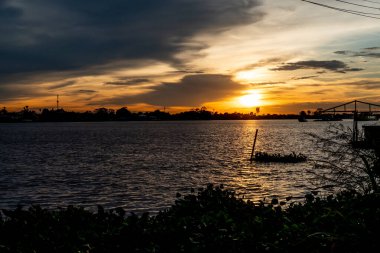 Nehir kenarındaki binanın siluetiyle gün batımı gökyüzü